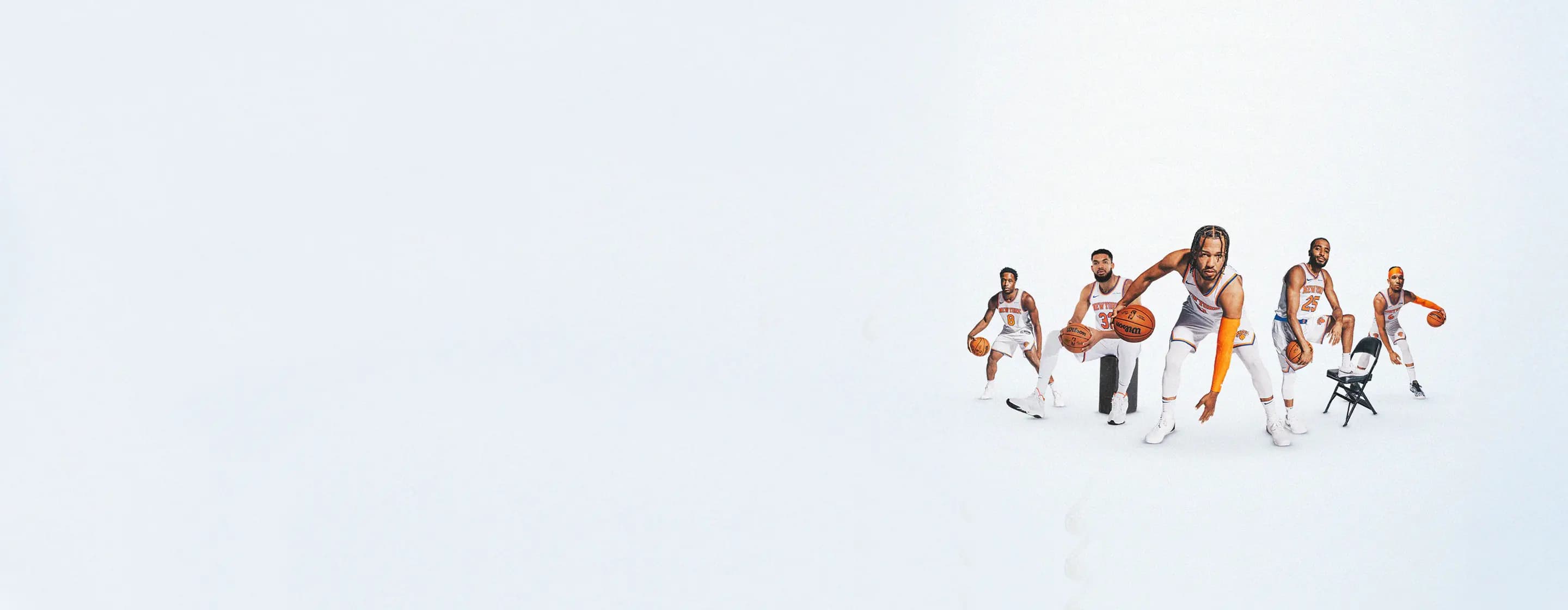 New York Knicks players posing in uniform with basketballs.
