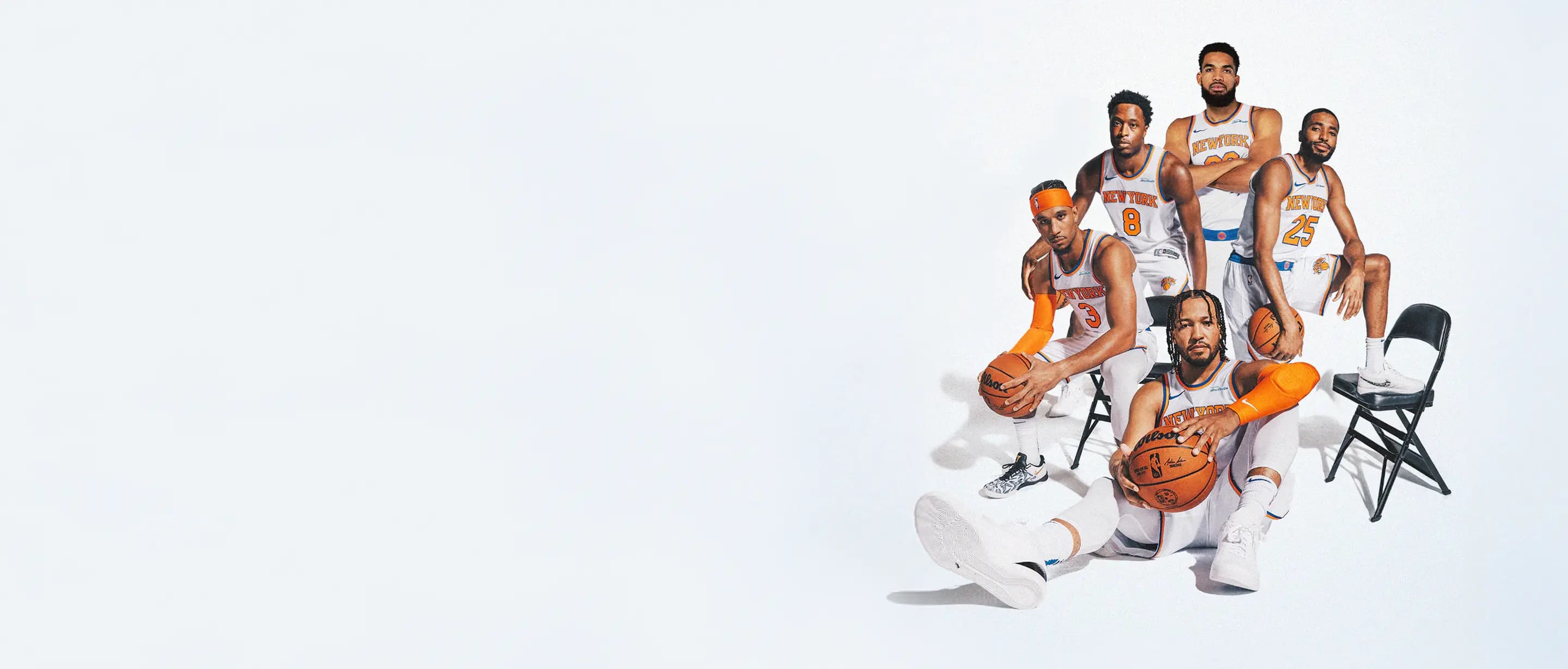 knicks basketball team posing with basketballs and chairs