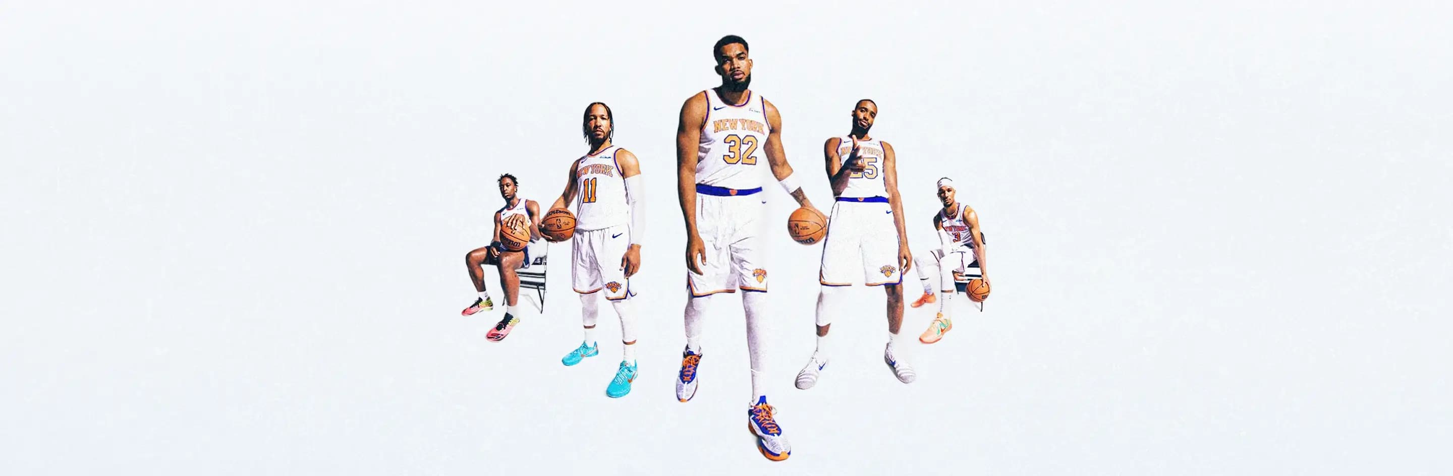 New York Knicks players posing in uniform with basketballs.